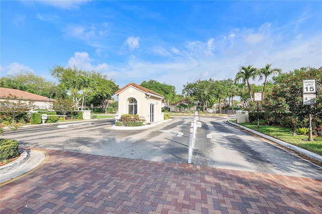 view of road with a gated entry and curbs