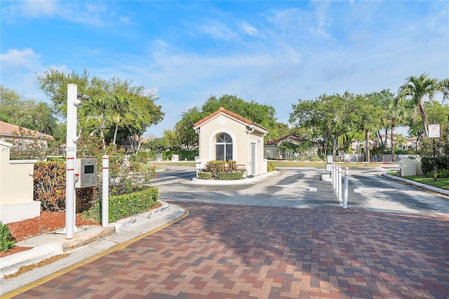 view of road featuring a gate, curbs, and a gated entry