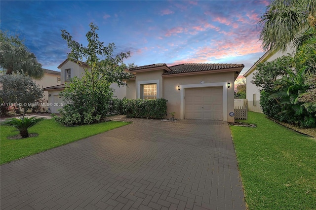 6244 NW 38th Dr, Coral Springs, FL 33067 - mediterranean / spanish-style home with decorative driveway, stucco siding, an attached garage, a tiled roof, and a yard