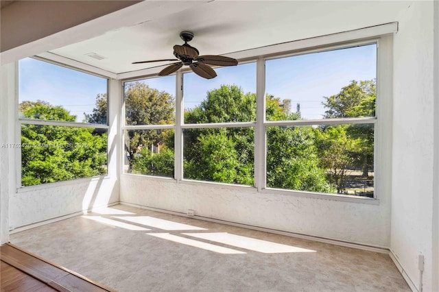 unfurnished sunroom with plenty of natural light, visible vents, and a ceiling fan