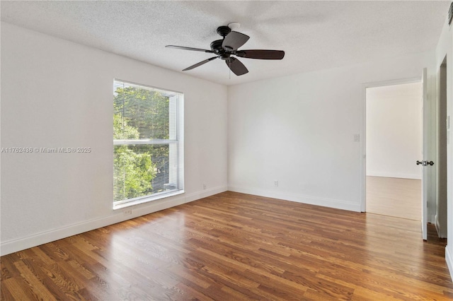 unfurnished room featuring ceiling fan, wood finished floors, baseboards, and a textured ceiling