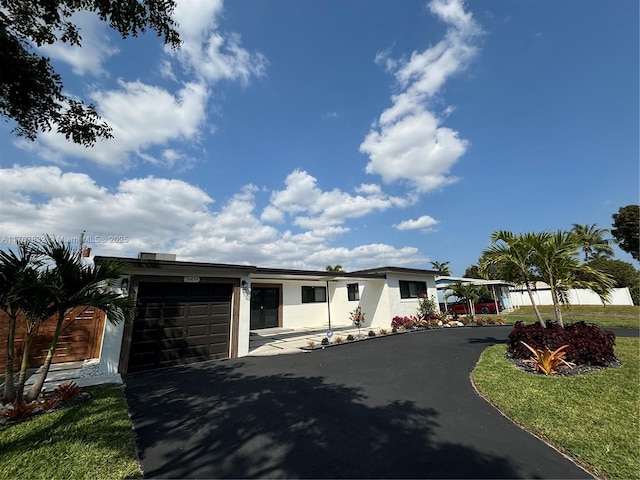 view of front of property featuring stucco siding, driveway, and a garage