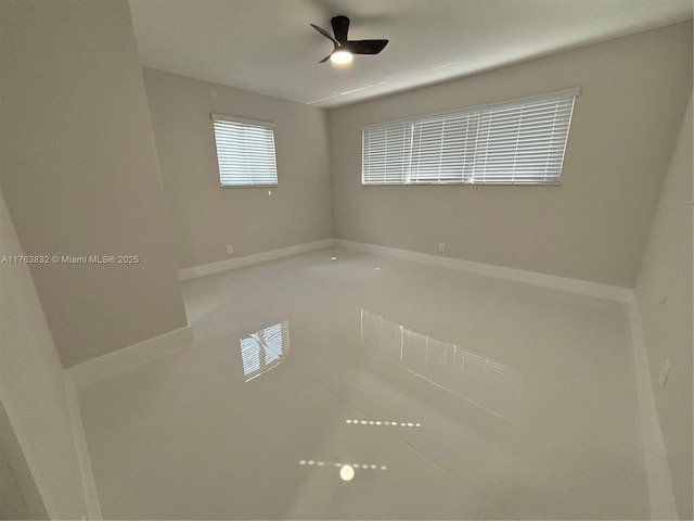 tiled spare room featuring baseboards and ceiling fan