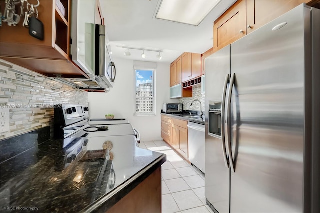 kitchen with a sink, tasteful backsplash, stainless steel appliances, a toaster, and light tile patterned floors