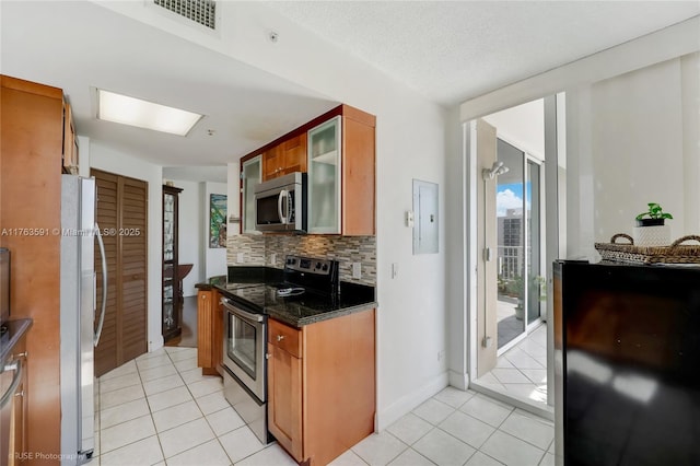 kitchen with light tile patterned floors, stainless steel appliances, visible vents, and decorative backsplash