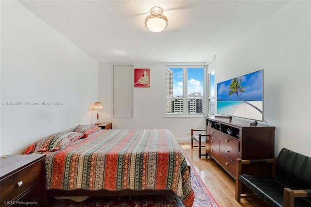 bedroom featuring light wood-type flooring and a textured ceiling