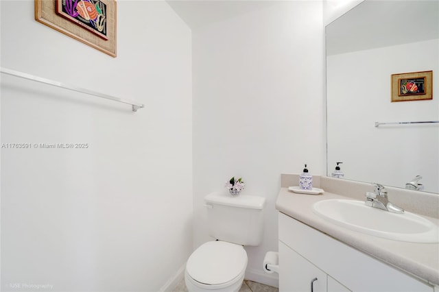 half bath with baseboards, toilet, and vanity