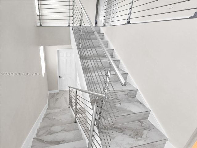 staircase with baseboards and marble finish floor