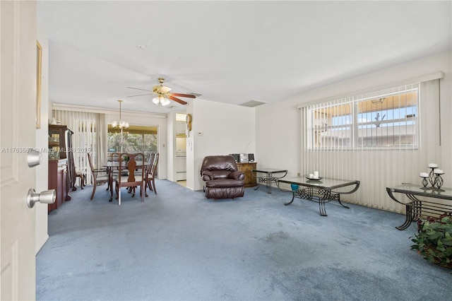 interior space featuring carpet flooring and ceiling fan with notable chandelier