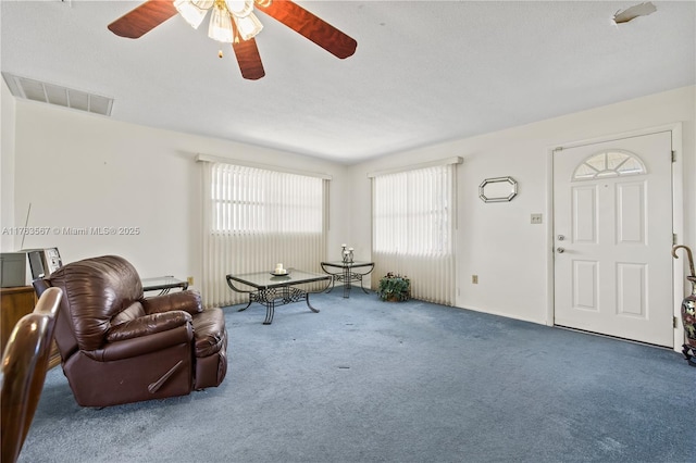 interior space with a wealth of natural light, visible vents, carpet, and a ceiling fan