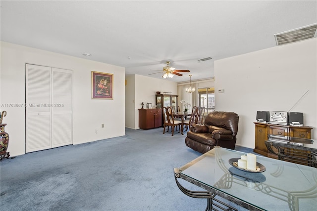 living area with ceiling fan with notable chandelier, carpet, and visible vents