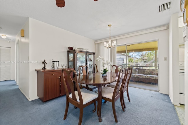 carpeted dining area with visible vents, baseboards, and ceiling fan with notable chandelier