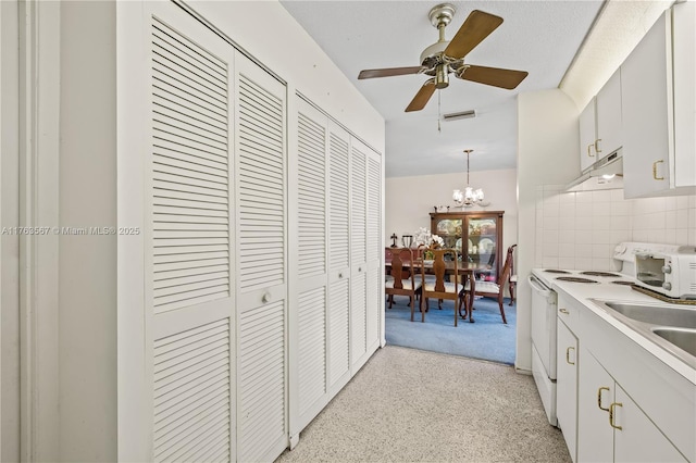 kitchen with visible vents, under cabinet range hood, decorative backsplash, ceiling fan with notable chandelier, and white range with electric stovetop