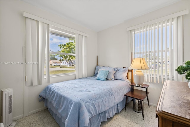 bedroom featuring speckled floor and baseboards