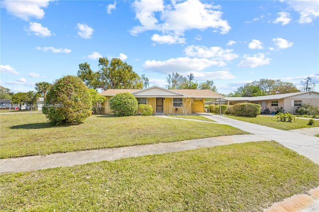 ranch-style house with a front lawn, an attached carport, and driveway