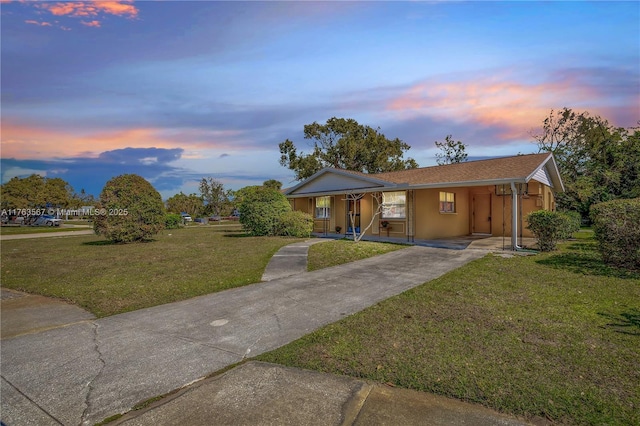 single story home featuring an attached carport, driveway, and a front lawn