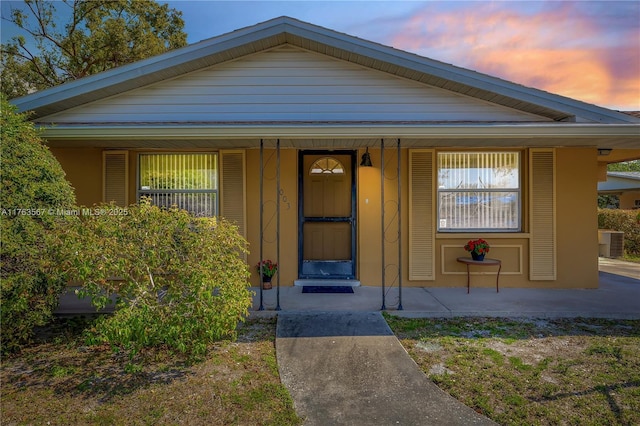 exterior entry at dusk with a porch and central AC