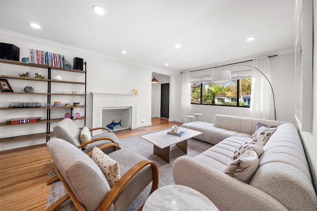 living room featuring recessed lighting, light wood finished floors, and ornamental molding