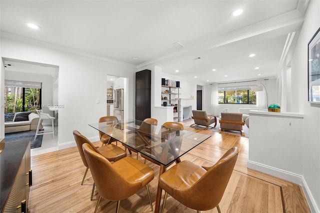 dining area with recessed lighting, crown molding, and light wood-style floors