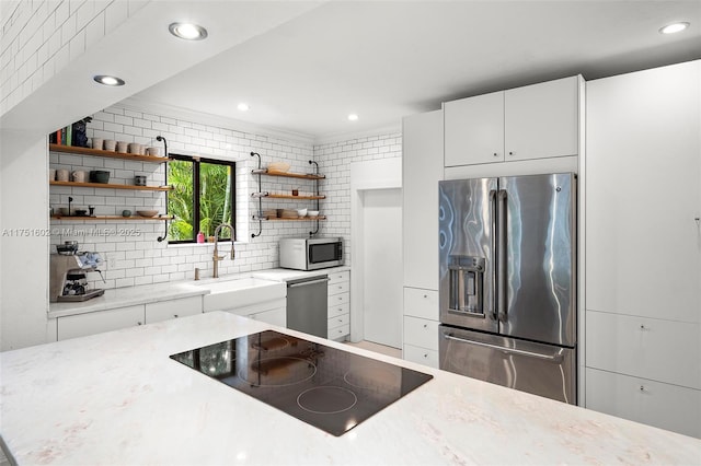 kitchen with open shelves, a sink, backsplash, stainless steel appliances, and white cabinets