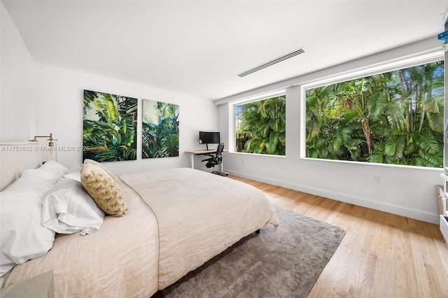 bedroom with light wood-type flooring, visible vents, and baseboards