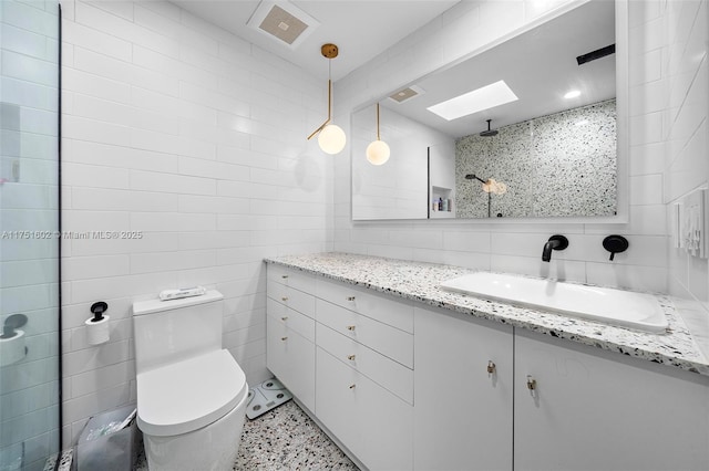 bathroom featuring visible vents, a skylight, tile walls, toilet, and backsplash