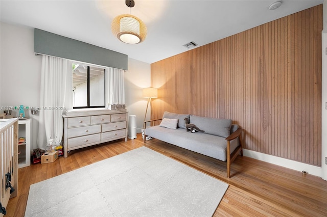 bedroom with visible vents, baseboards, and wood finished floors