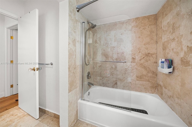 bathroom featuring combined bath / shower with glass door