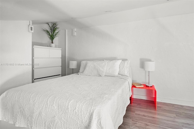 bedroom with wood finished floors and baseboards