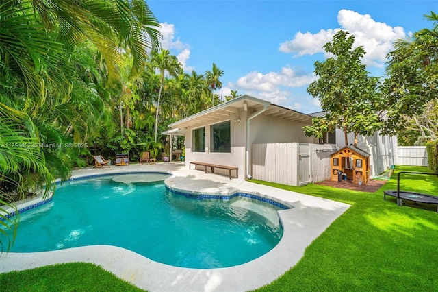 view of swimming pool with a yard, fence, a fenced in pool, and a patio area