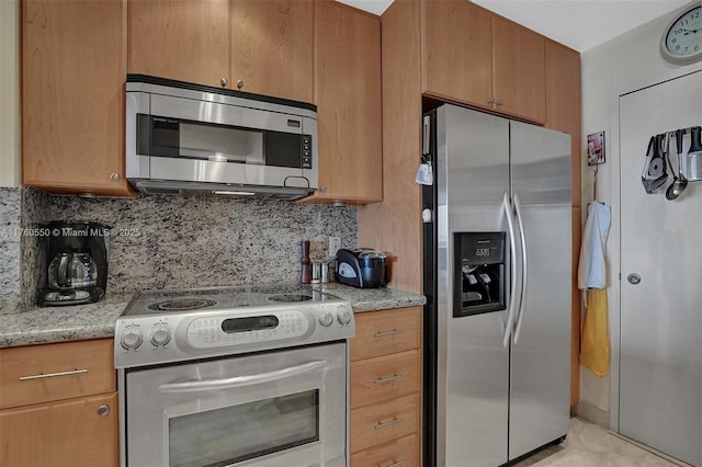 kitchen with light tile patterned floors, stainless steel appliances, light stone countertops, and tasteful backsplash