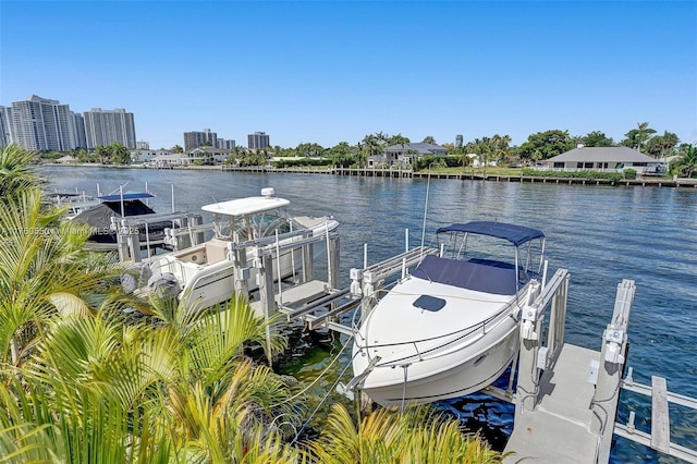 dock area with a view of city, a water view, and boat lift