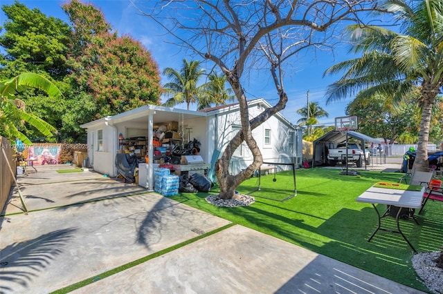 exterior space with concrete driveway, a yard, and fence