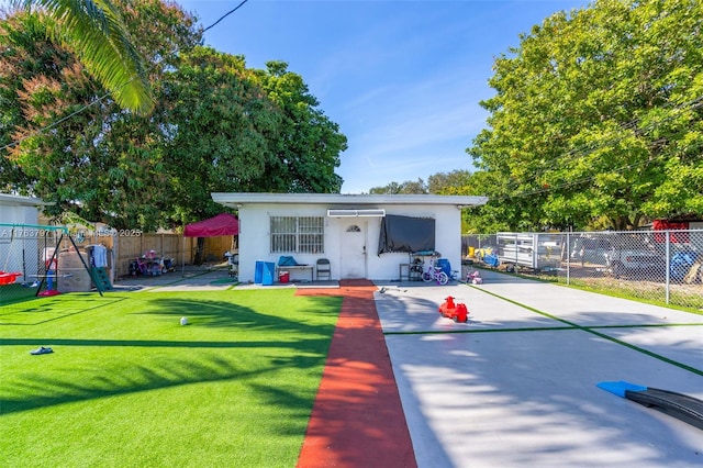 view of front of home with a patio area, a fenced backyard, stucco siding, and a playground