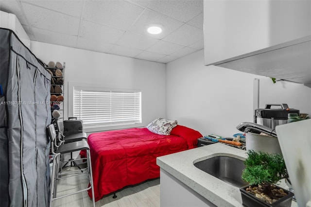 bedroom featuring a drop ceiling and a sink