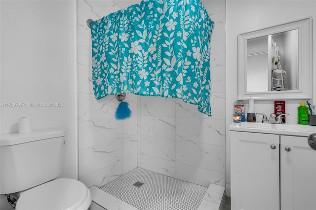 full bath with a tile shower, toilet, and vanity