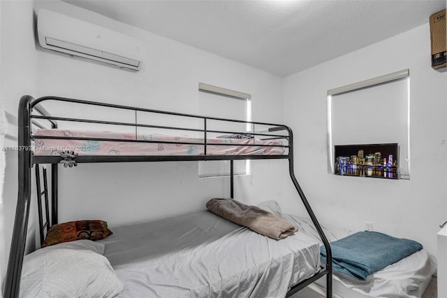 bedroom with a textured ceiling and a wall mounted AC