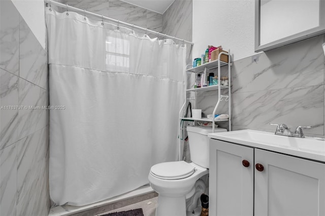 full bathroom with toilet, curtained shower, tile walls, and vanity