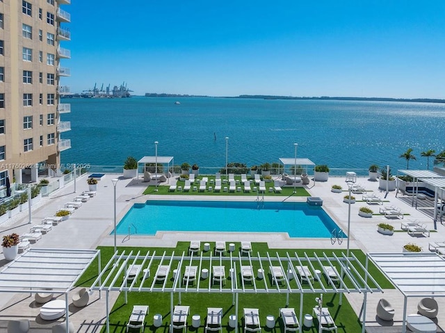 community pool with a patio and a water view