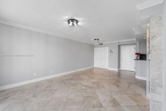 unfurnished room with visible vents, a textured ceiling, crown molding, and baseboards