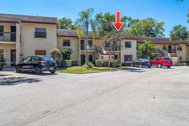 view of property with a residential view and uncovered parking