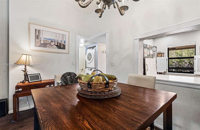 dining area with stacked washer / dryer, dark wood-type flooring, and a textured wall