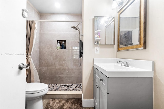 bathroom featuring vanity, a shower stall, and toilet