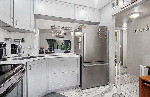 3059 Carambola Cir S Unit 2033, Coconut Creek, FL 33066 - kitchen with freestanding refrigerator, a chandelier, light countertops, a sink, and black electric range oven