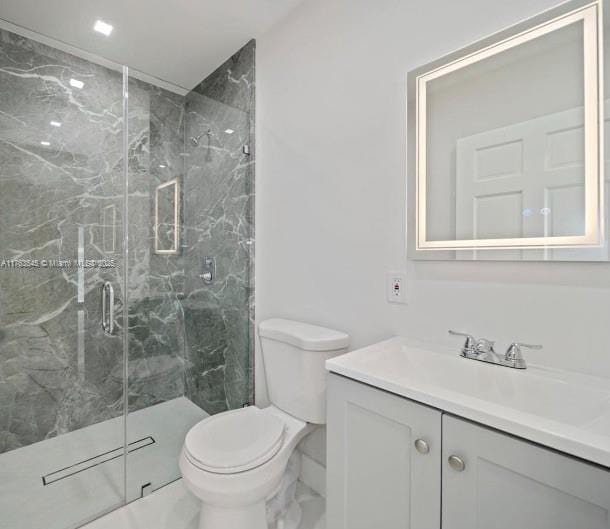 full bath with vanity, toilet, and a marble finish shower