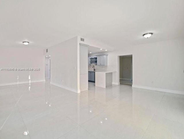 empty room featuring a sink, visible vents, and baseboards