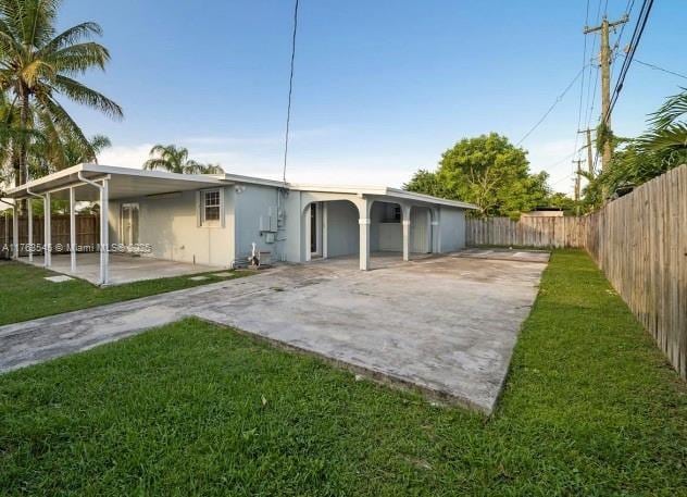 back of property with a patio area, a lawn, a fenced backyard, and stucco siding