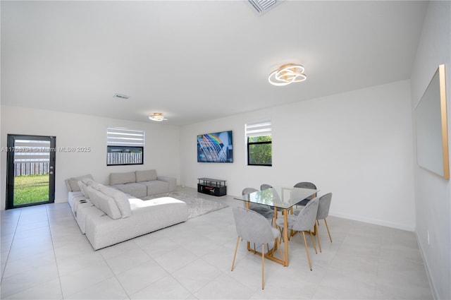 living area featuring baseboards and visible vents