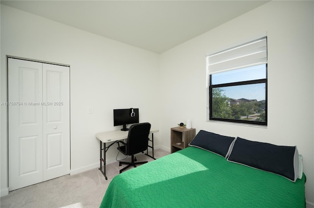 bedroom with a closet, baseboards, and light colored carpet