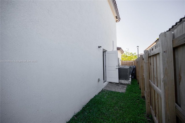 view of property exterior with stucco siding and fence